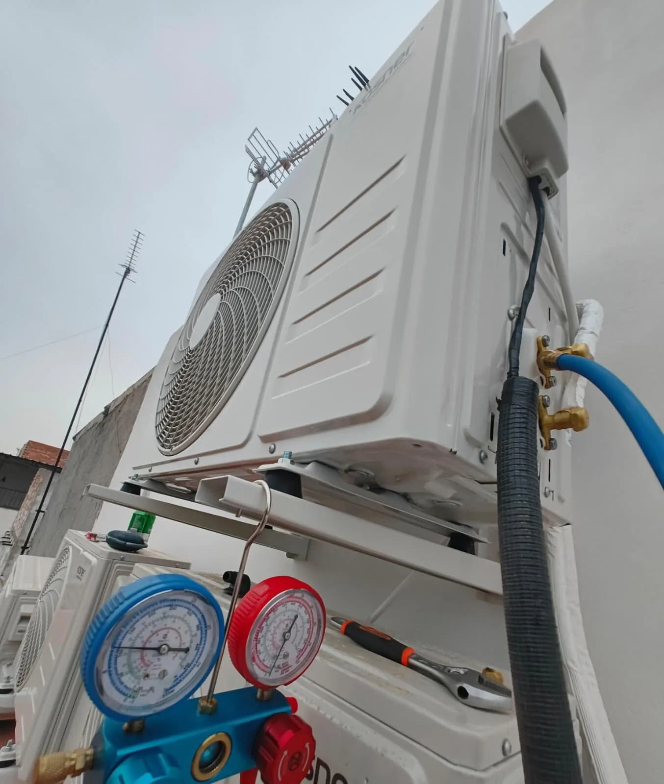 Unidad exterior de aire acondicionado con manómetros de carga conectados