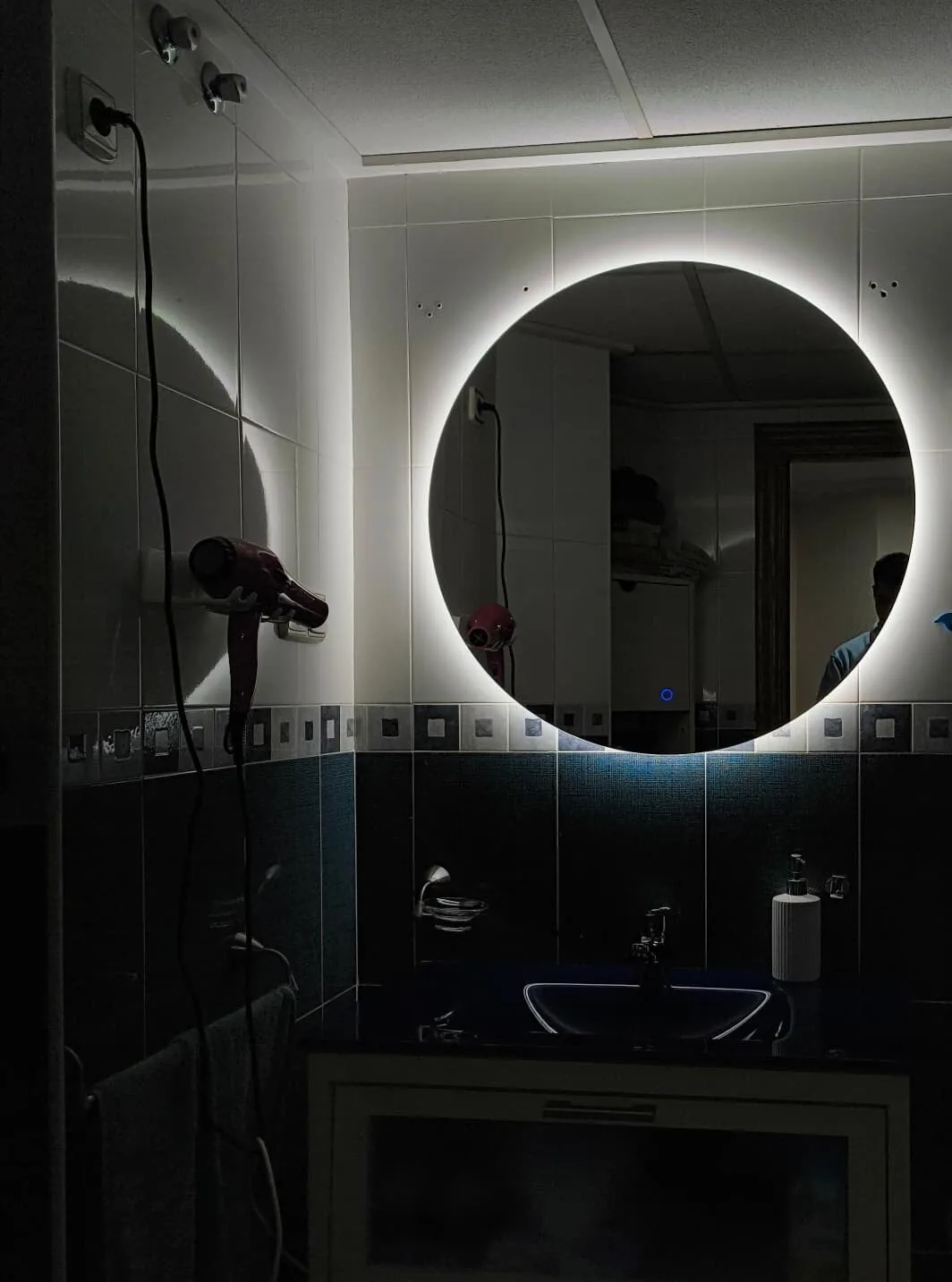 Espejo circular retroiluminado instalado en un baño