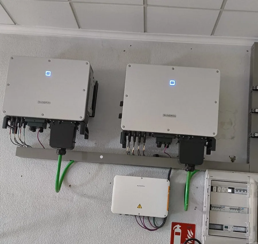 Dos inversores solares Sungrow instalados en pared con su caja de continua y cuadro de protecciones